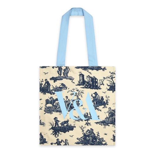 A blue and white cotton tote bag bearing a pattern featuring pastoral scenes. The handles and logo on the front are a pastel shade of blue.